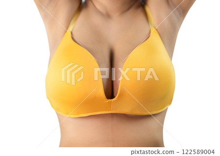 Woman with beautiful breasts sexy bikini bra a yellow on a white background, closeup. Woman with beautiful breasts sexy bikini bra a yellow on a white background, closeup. 122589004