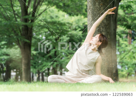 年輕的亞洲女性在公園做瑜珈、瑜珈、皮拉提斯、在森林/公園伸展運動 年輕的亞洲女性在公園做瑜珈、瑜珈、皮拉提斯、在森林/公園伸展運動 122589063