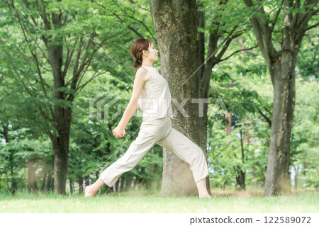 年輕的亞洲女性在公園做瑜珈、瑜珈、皮拉提斯、在森林/公園伸展運動 122589072