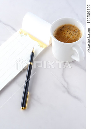 An image of someone writing a letter on a notepad while drinking freshly brewed delicious coffee An image of someone writing a letter on a notepad while drinking freshly brewed delicious coffee 122589392