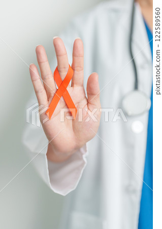 Doctor with Orange Ribbon for Leukemia, Kidney cancer day, world Multiple Sclerosis, CRPS, Self Injury Awareness month. Healthcare and word cancer day concept Doctor with Orange Ribbon for Leukemia, Kidney cancer day, world Multiple Sclerosis, CRPS, Self Injury Awareness month. Healthcare and word cancer day concept 122589560