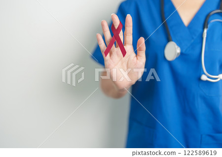 Doctor with Burgundy Red Ribbon for March multiple myeloma Cancer and December World Aids Day Awareness month. Healthcare and world cancer day concept 122589619