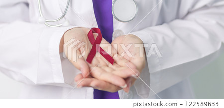 Doctor with Burgundy Red Ribbon for March multiple myeloma Cancer and December World Aids Day Awareness month. Healthcare and world cancer day concept 122589633