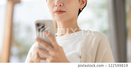 A woman looking at her smartphone with a serious look A woman looking at her smartphone with a serious look 122589819
