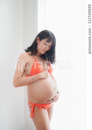 Asia sexy pregnant mother in red bikini in the bedroom 122589888