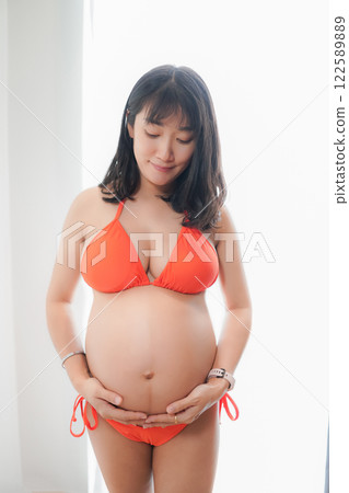 Asia sexy pregnant mother in red bikini in the bedroom 122589889
