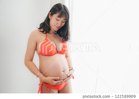 Asia sexy pregnant mother in red bikini in the bedroom 122589909