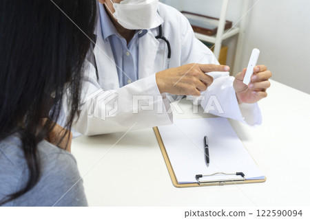 Male doctor show Rapid Antigen Test kit with Negative result to female patient. 122590094