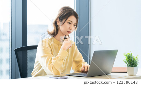 A woman/businesswoman thinking while looking at a computer screen 122590148