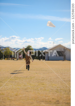 A girl flying a kite under the blue sky 122590193