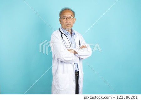 portrait of senior Asian doctor with serious face standing on blue background. 122590201