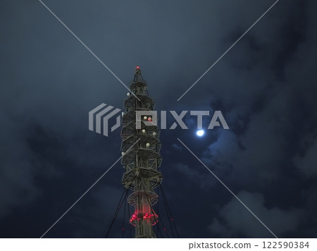 A radio tower towering into the night sky A radio tower towering into the night sky 122590384