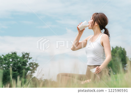 A woman drinking protein and EAA during exercise A woman drinking protein and EAA during exercise 122590591