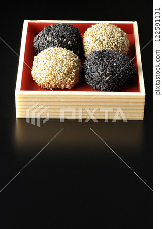 在黑色背景下拍攝的白色和黑色芝麻球 122591131