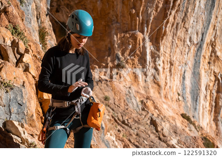 Girl is climbing on the red rocks, leads an active lifestyle. Girl is climbing on the red rocks, leads an active lifestyle. 122591320