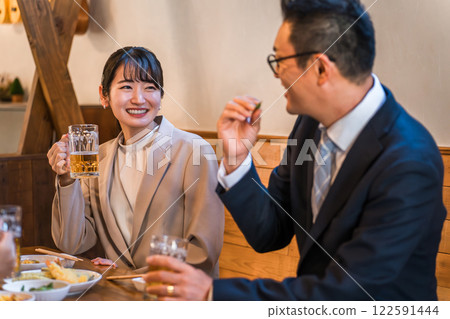 Male and female office workers chatting at an izakaya or bar Male and female office workers chatting at an izakaya or bar 122591444