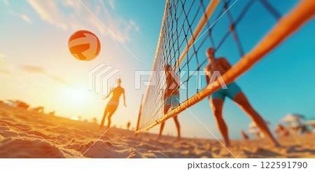 Beach volleyball game at sunset with players and flying ball 122591790