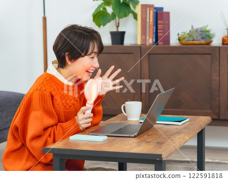 一名中年婦女正在用筆記型電腦觀看直播 一名中年婦女正在用筆記型電腦觀看直播 122591818