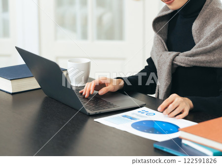Woman working on laptop at desk 122591826