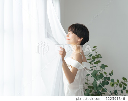 Middle woman opening the curtain Middle woman opening the curtain 122591846
