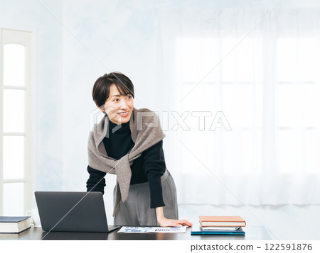 Middle-aged woman working at a desk Middle-aged woman working at a desk 122591876