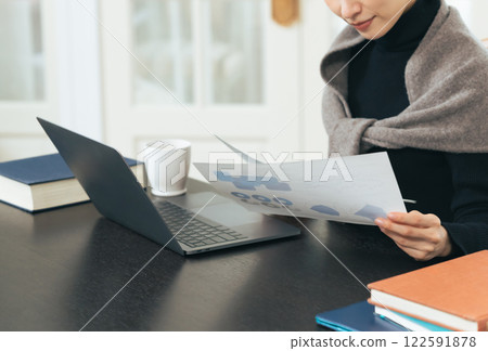 A middle-aged woman checking data on a laptop A middle-aged woman checking data on a laptop 122591878