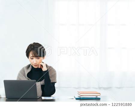 在辦公桌上使用筆記型電腦工作的女性 122591880