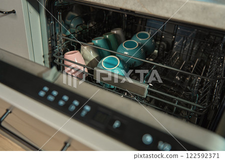 Dishwasher loaded with ceramic cups and bowls 122592371
