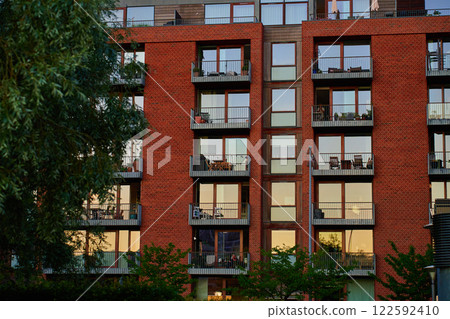 Modern red brick apartment building with balconies at sunset Modern red brick apartment building with balconies at sunset 122592410