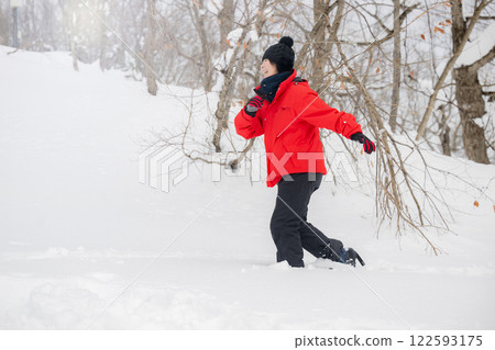 在雪山中進行冬季運動的婦女穿著雪鞋行走 冬季活動 在雪山中進行冬季運動的婦女穿著雪鞋行走 冬季活動 122593175