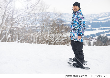 一名男子在雪山中進行冬季運動雪鞋行走 122593178