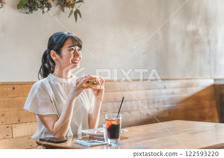 Asian woman having lunch and eating at restaurant, cafe, employee cafeteria Asian woman having lunch and eating at restaurant, cafe, employee cafeteria 122593220