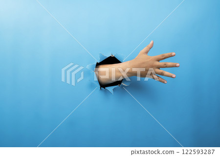 Human hand showing from ripped paper. Hand gestures of rejection or counting. Mockup or Copy space. Concept of sign or communication Human hand showing from ripped paper. Hand gestures of rejection or counting. Mockup or Copy space. Concept of sign or communication 122593287