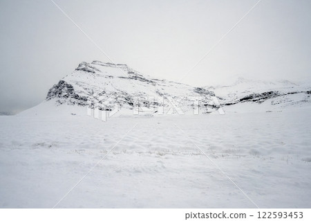 Landscape view of snow covered fields and mountains in Iceland. Nature, travel, winter background, or wallpaper 122593453