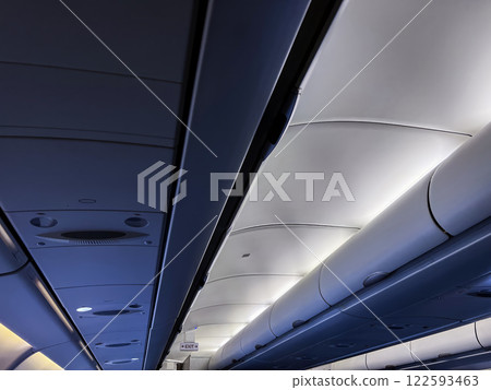 View of the airplane cabin with modern interior lighting. Traveling concept View of the airplane cabin with modern interior lighting. Traveling concept 122593463
