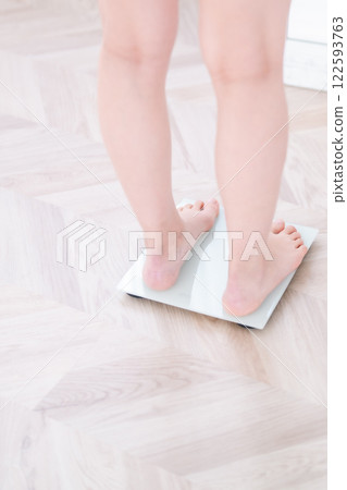 Young woman on a weight scale, no face 122593763