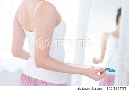 Woman on a diet holding a tape measure, no face Woman on a diet holding a tape measure, no face 122593765