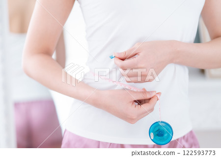 Woman on a diet holding a tape measure, no face Woman on a diet holding a tape measure, no face 122593773