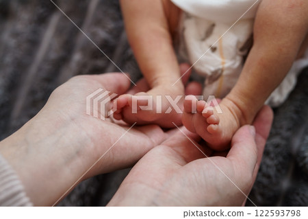 Tender Moment: A Parent's Hands Gently Cradling a Baby's Tiny Feet 122593798