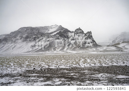 Landscape view of snow covered fields and mountains in Iceland. Nature, travel, winter background, or wallpaper Landscape view of snow covered fields and mountains in Iceland. Nature, travel, winter background, or wallpaper 122593841