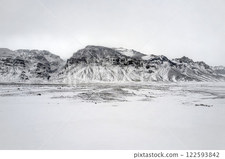 Landscape view of snow covered fields and mountains in Iceland. Nature, travel, winter background, or wallpaper Landscape view of snow covered fields and mountains in Iceland. Nature, travel, winter background, or wallpaper 122593842