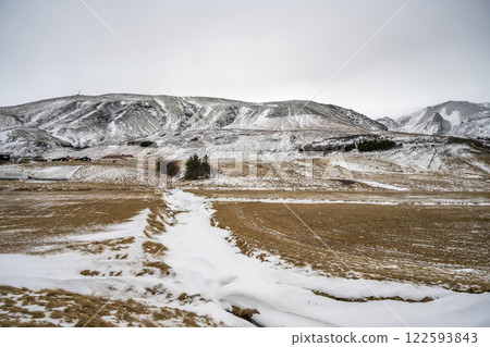 Landscape view of snow covered fields and mountains in Iceland. Nature, travel, winter background, or wallpaper Landscape view of snow covered fields and mountains in Iceland. Nature, travel, winter background, or wallpaper 122593843