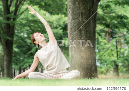 年輕的亞洲女性在公園做瑜珈、瑜珈、皮拉提斯、在森林/公園伸展運動 年輕的亞洲女性在公園做瑜珈、瑜珈、皮拉提斯、在森林/公園伸展運動 122594578
