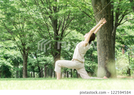 年輕的亞洲女性在公園做瑜珈、瑜珈、皮拉提斯、在森林/公園伸展運動 122594584