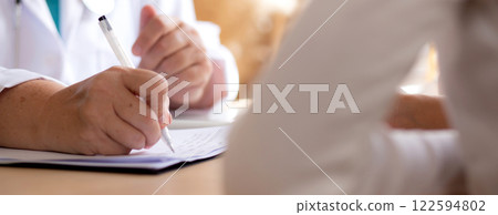 Senior woman doctor consults with young patient in modern medical office, doctor explaining. Senior woman doctor consults with young patient in modern medical office, doctor explaining. 122594802
