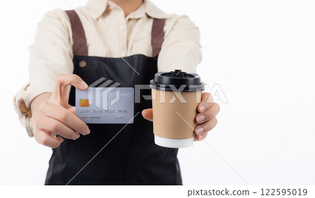 Closeup hand of woman wearing apron holding credit card isolated white background. 122595019