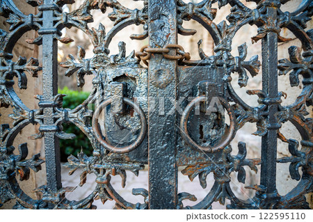 Close-Up of an Old Metal Gate with a Lock on Sveti Stefan Island, Montenegro. A Historic and Weathered Entrance Close-Up of an Old Metal Gate with a Lock on Sveti Stefan Island, Montenegro. A Historic and Weathered Entrance 122595110