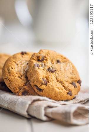 Chocolate chip cookies on napkin on white table. 122595117