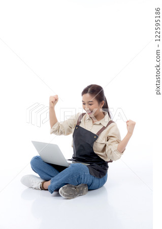 Portrait young asian business woman wearing apron holding laptop computer isolated. Portrait young asian business woman wearing apron holding laptop computer isolated. 122595186