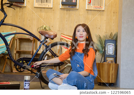 Young woman repairing a bicycle Young woman repairing a bicycle 122596065